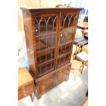 A REPRODUCTION MAHOGANY TWO DOOR GLAZED BOOKCASE ON BASE WITH TWO CUPBOARDS, 40" WIDE