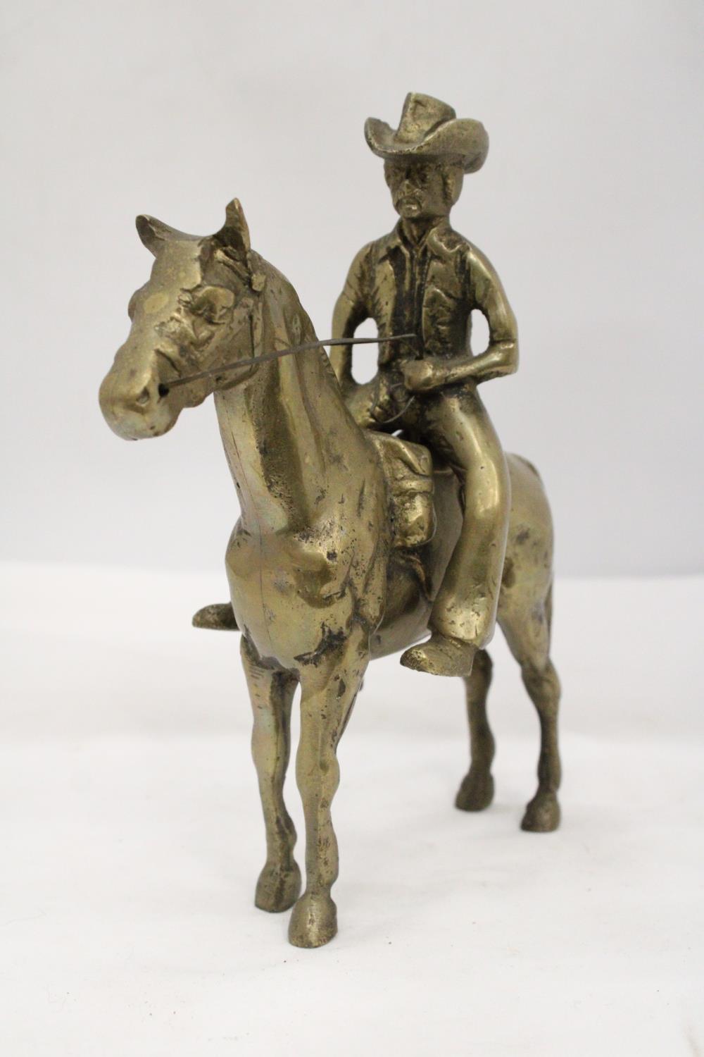 AN UNUSUAL SOLID BRASS COWBOY AND HORSE - APPROXIMATELY 22CM X 22CM - WEIGHS OVER TWO KILO