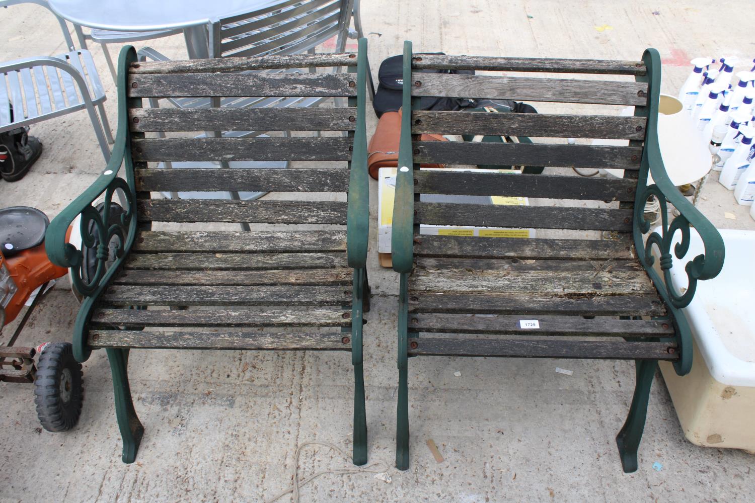 A PAIR OF WOODEN SLATTED GARDEN CHAIRS WITH DECORATIVE CAST ENDS