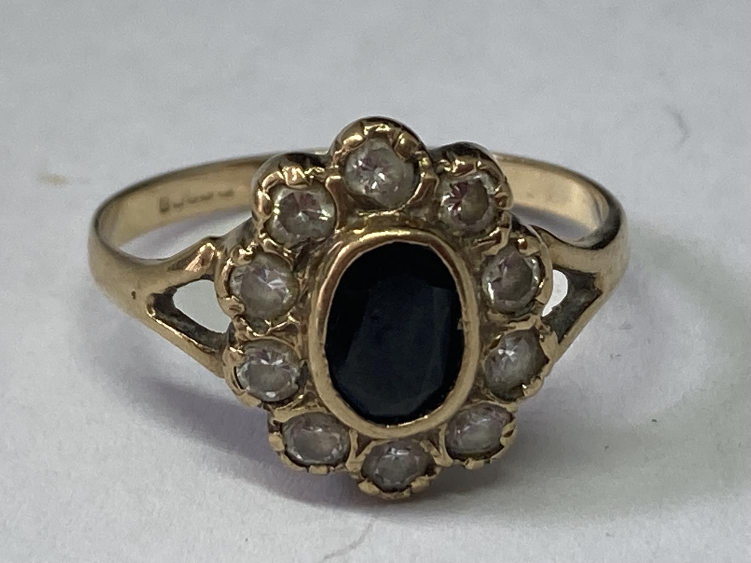A 9 CARAT GOLD RING WITH CENTRE SAPPHIRE SURROUNDED BY CUBIC ZIRCONIAS SIZE R/S