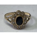 A 9 CARAT GOLD RING WITH CENTRE SAPPHIRE SURROUNDED BY CUBIC ZIRCONIAS SIZE R/S