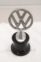 A CHROME VW LOGO ON A BASE, HEIGHT 21CM