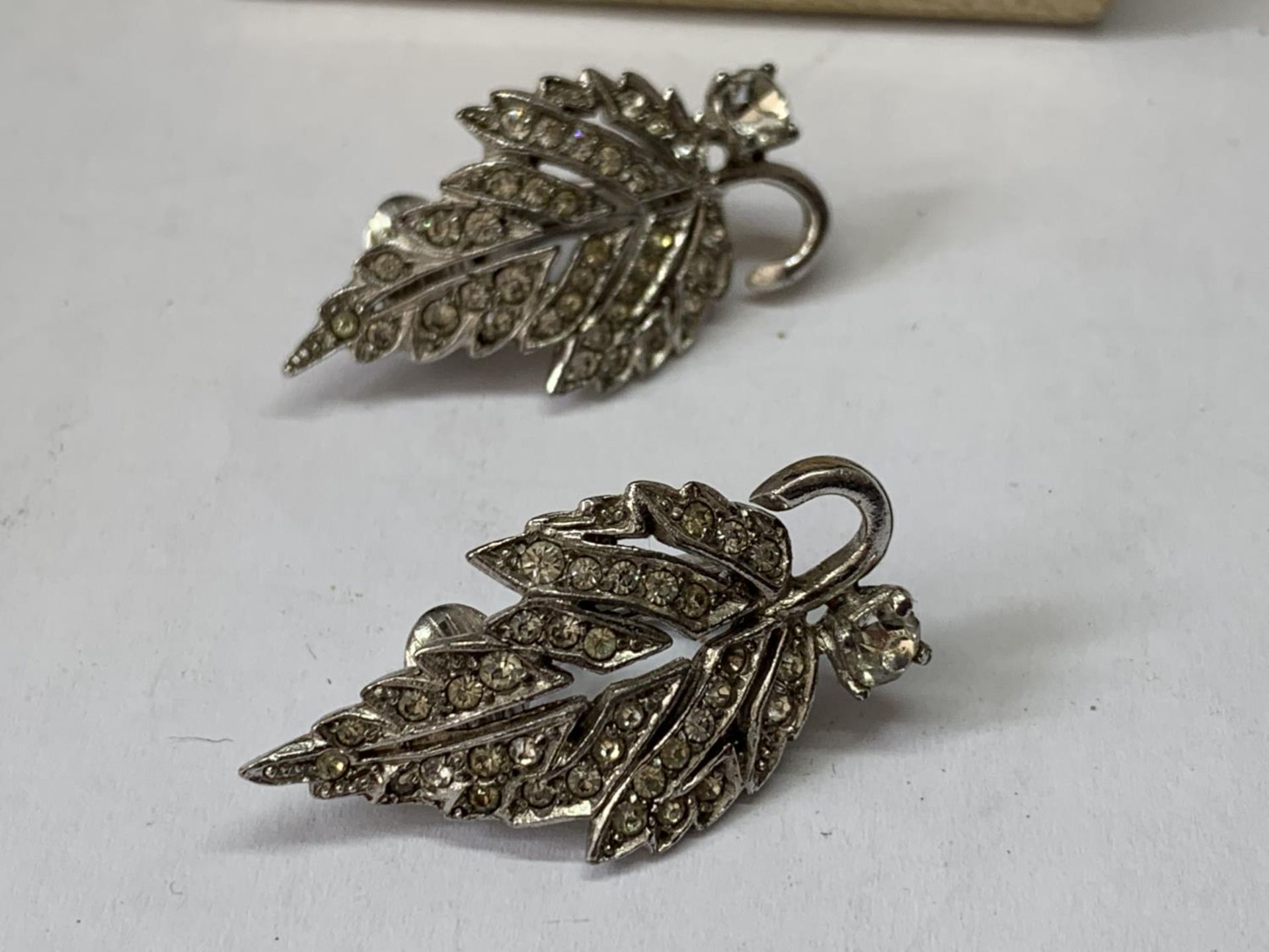 A PAIR OF 1940'S METAL RHODIUM AND CLEAR STONE EARRINGS IN A LEAF DESIGN WITH PRESENTATION BOX - Image 2 of 3