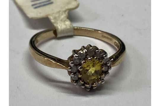 A 9 CARAT GOLD RING WITH CENTRECITRINE SURROUNDED BY CLEAR STONES SIZE K/L IN A PRESENTATION BOX - Image 3 of 4