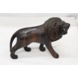 A VINTAGE HARDWOOD CARVED LION, WITH PATINA, WEIGHS NEAARLY 3 KILOS, HEIGHT 20CM, LENGTH 32CM