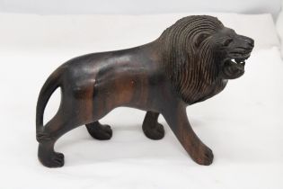 A VINTAGE HARDWOOD CARVED LION, WITH PATINA, WEIGHS NEAARLY 3 KILOS, HEIGHT 20CM, LENGTH 32CM