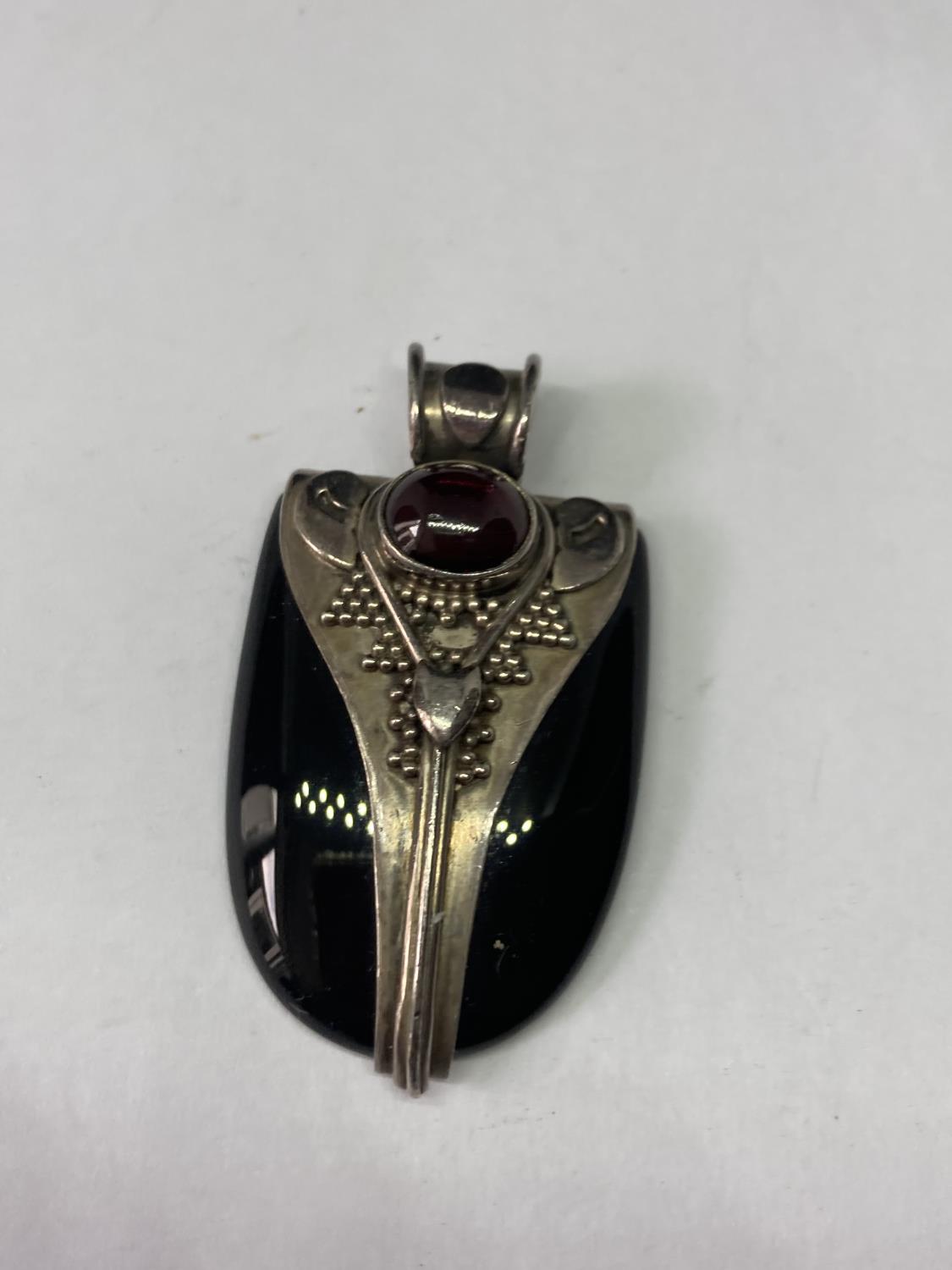 A SILVER AND BLACK STONE PENDANT