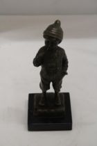 A BRONZE BOY SMOKING A CIGAR ON A MARBLE BASE - SIGNED