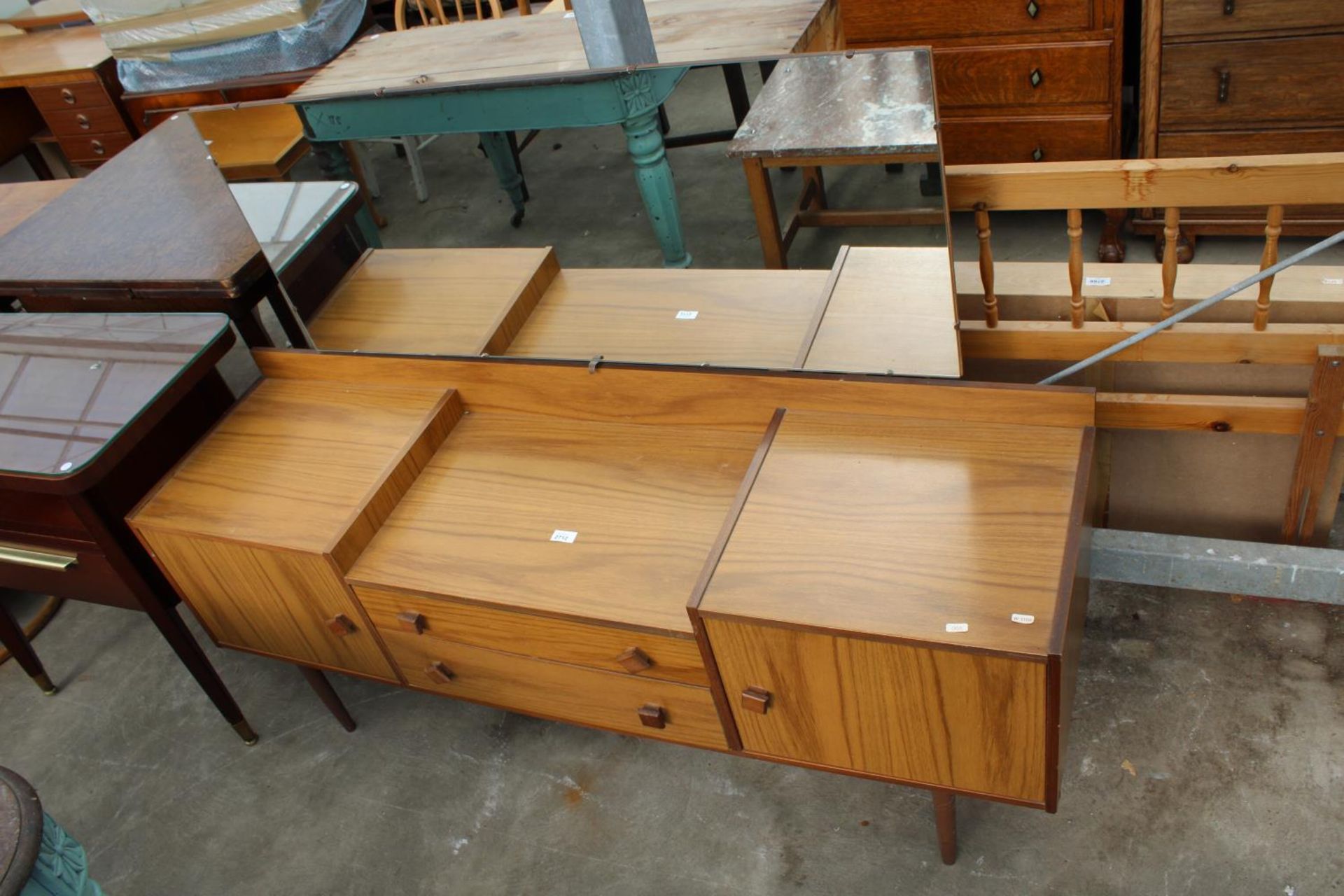 A RETRO TEAK LOW DRESSING TABLE ENCLOSING TWO DRAWERS AND TWO CUPBOARDS, 60" WIDE