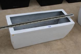 A SINGLE WHITE LOW FIBRE GLASS TROUGH PLANTER (H:20 L:49CM)