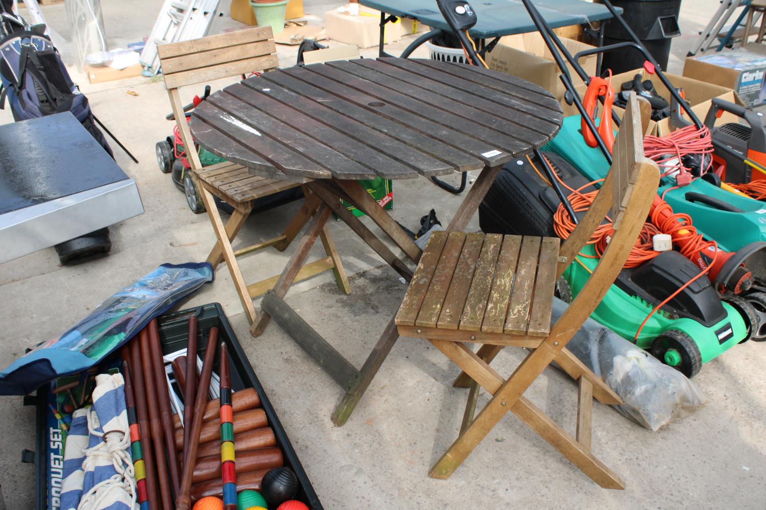 A WOODEN SLATTED ROUND TABLE AND TWO FOLDING CHAIRS