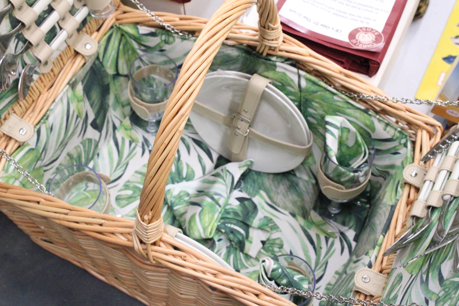 A WICKER PICNIC BASKET WITH LEAF PATTERN INTERIOR TO INCLUDE KNIVES, FORKS, SPOONS, PLATES, SALT AND - Image 3 of 7