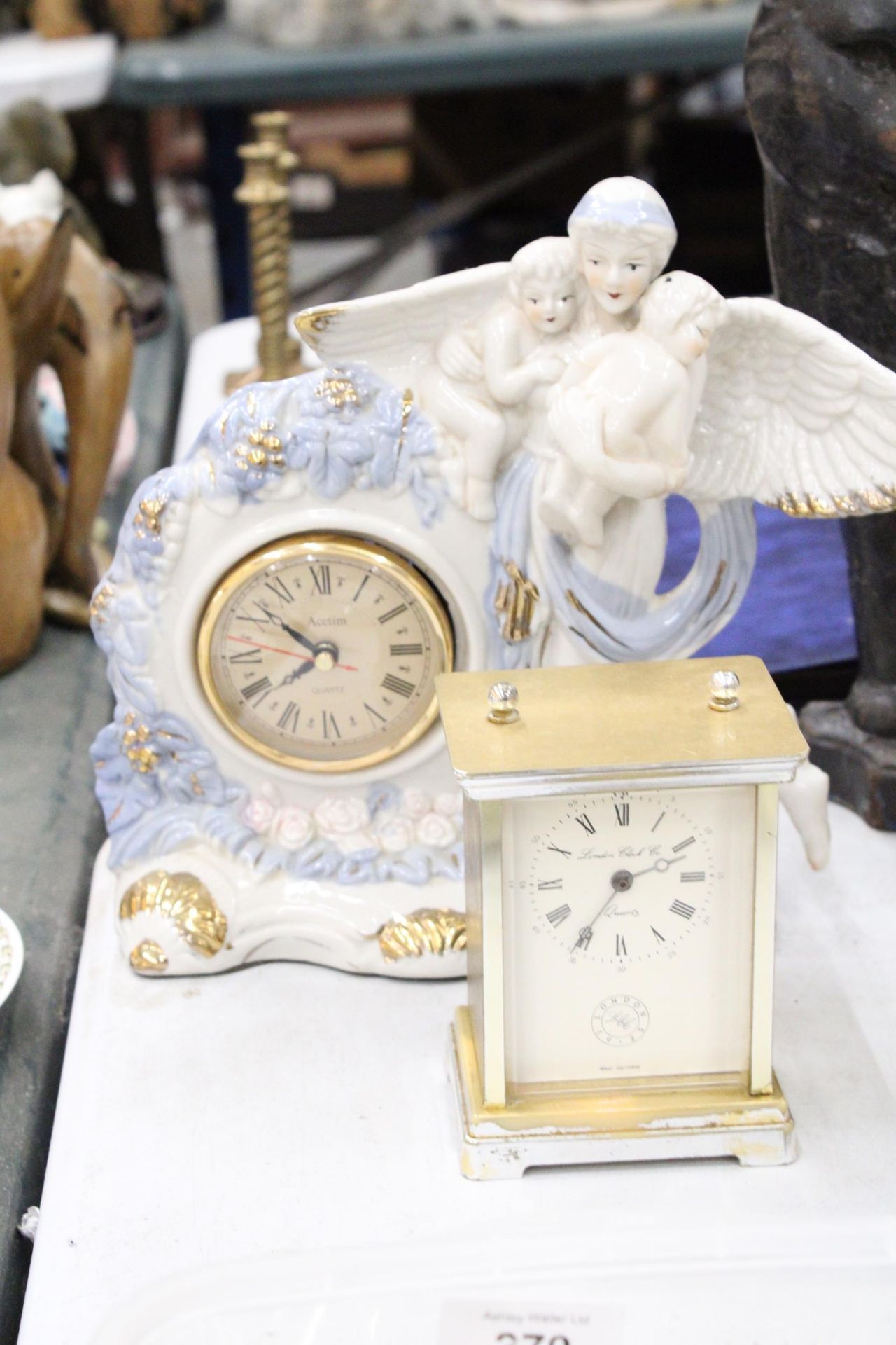TWO MANTLE CLOCKS TO INCLUDE A CERAMIC ANGEL WITH CHILDREN, PLUS A CARRIAGE CLOCK