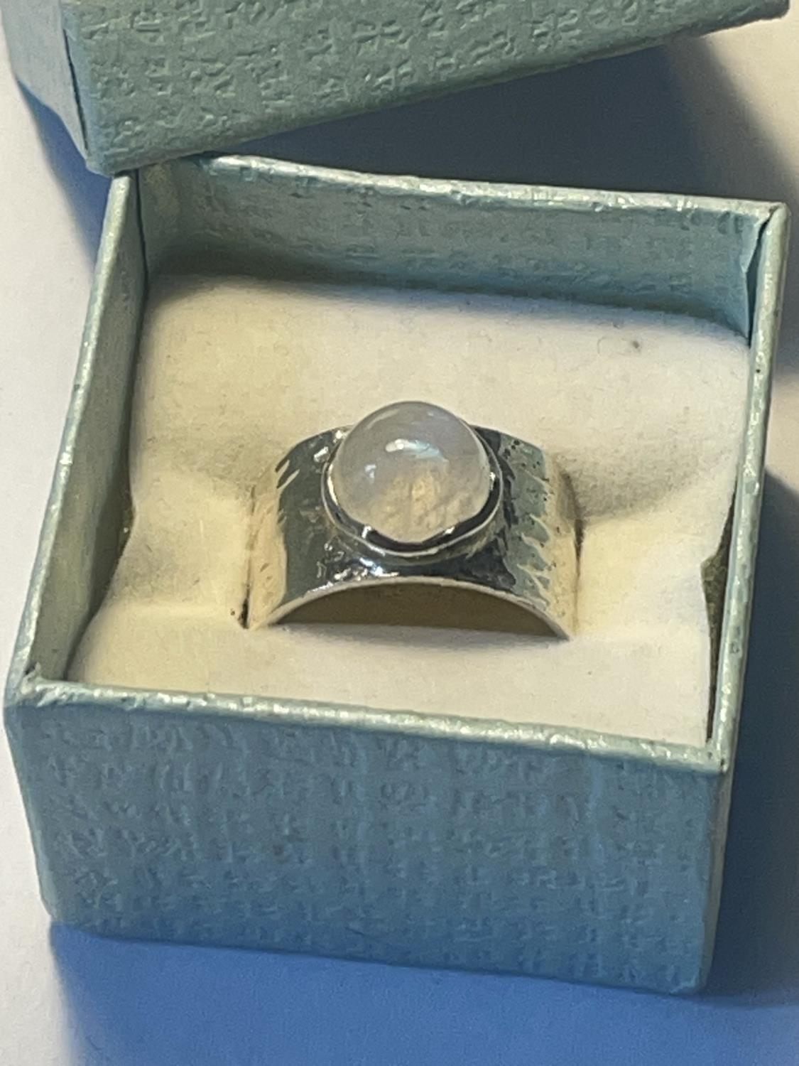 A SILVER RING WITH OPAQUE STONE IN A PRESENTATION BOX