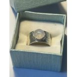 A SILVER RING WITH OPAQUE STONE IN A PRESENTATION BOX