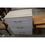 A MODERN CHEST OF THREE DRAWERS