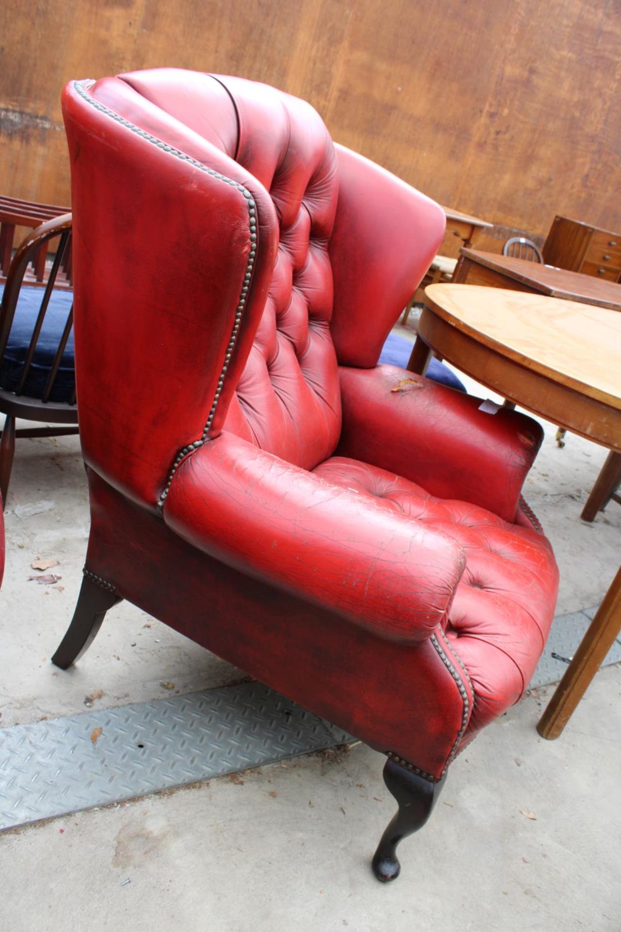 A RED LEATHER BUTTON-BACK WINGED FIRESIDE CHAIR ON FRONT CABRIOLE LEGS - Image 2 of 2
