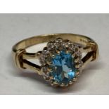 A 9 CARAT GOLD RING WITH A LARGE CENTRE TOPAZ SURROUNDED BY DIAMONDS SIZE Q/R
