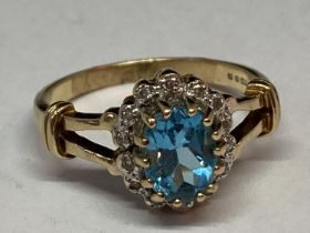 A 9 CARAT GOLD RING WITH A LARGE CENTRE TOPAZ SURROUNDED BY DIAMONDS SIZE Q/R