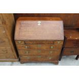 A GEORGE III OAK BUREAU WITH FITTED INTERIOR, TWO SHORT AND THREE LONG GRADUATED DRAWERS TO THE BASE