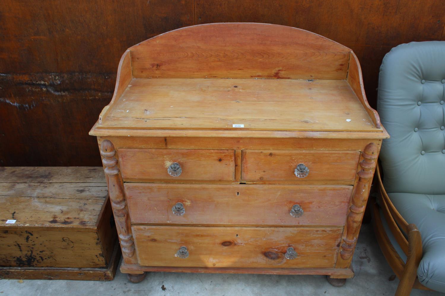 A VICTORIAN PINE GALLERIED BACK CHEST OF TWO SHORT AND TWO LONG GRADUATED DRAWERS WITH GLASS HANDLES