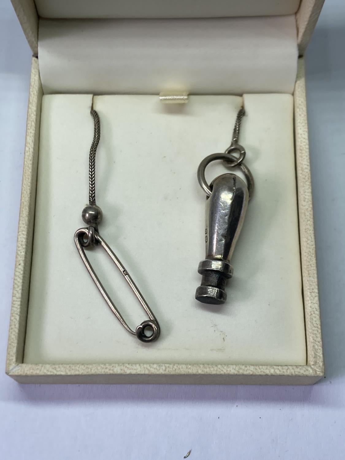 A SILVER SEAL ON A SILVER CHAIN IN A PRESENTATION BOX