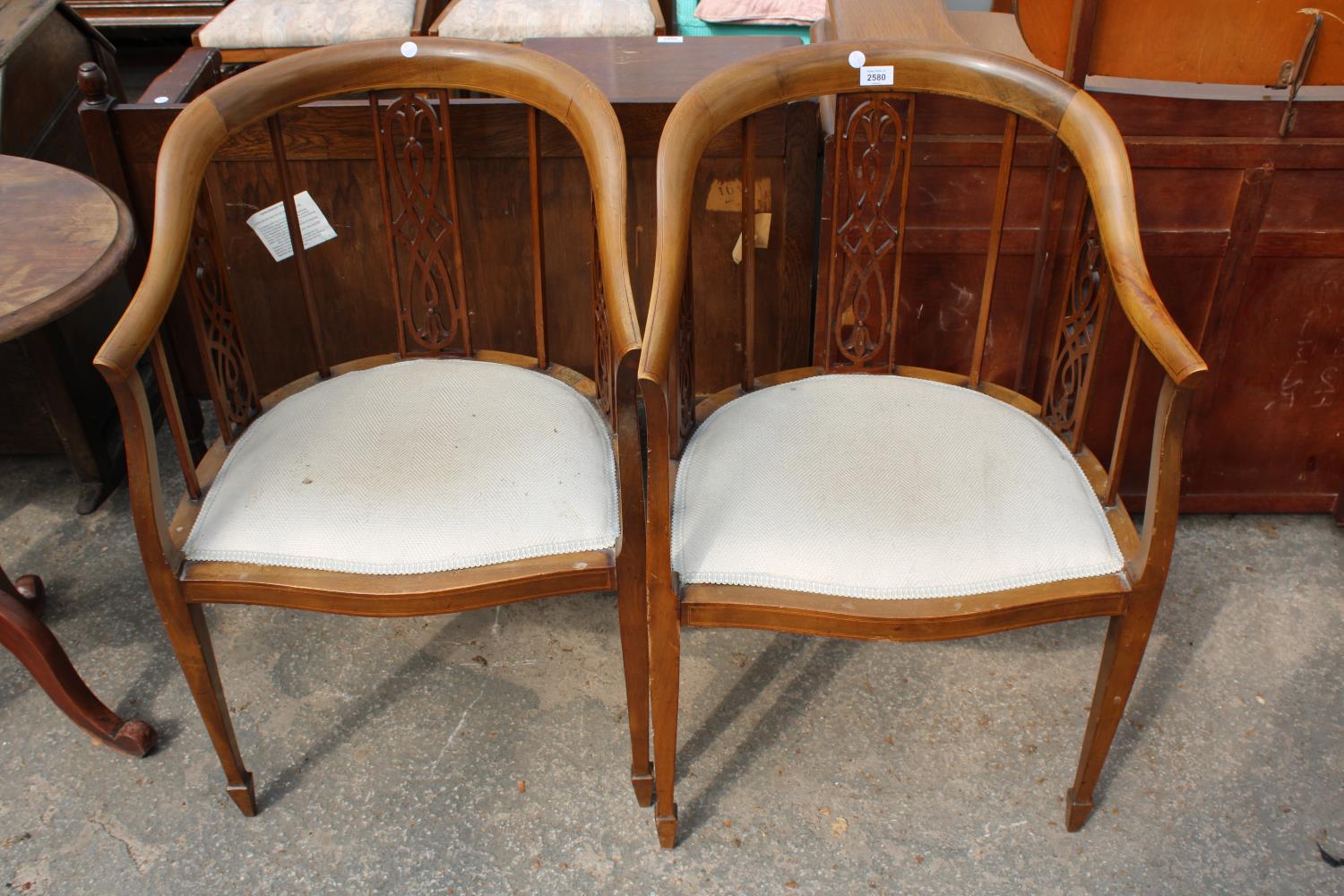 A PAIR OF EDWARDIAN MAHOGANY AND INLAID TUB CHAIRS WITH SWEPT BACKS, ARMS AND PIERCED PANELS