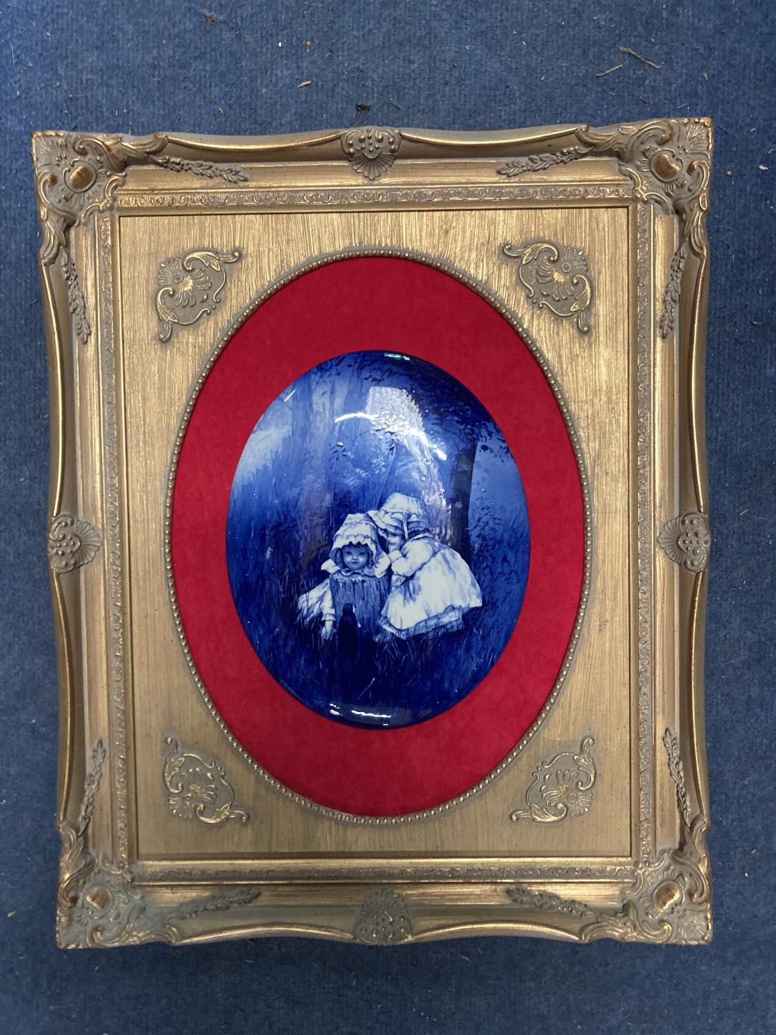 A CERAMIC PLAQUE OF BABES IN THE WOODS, IN AN ORNATE GILT FRAME, 43CM X 54CM