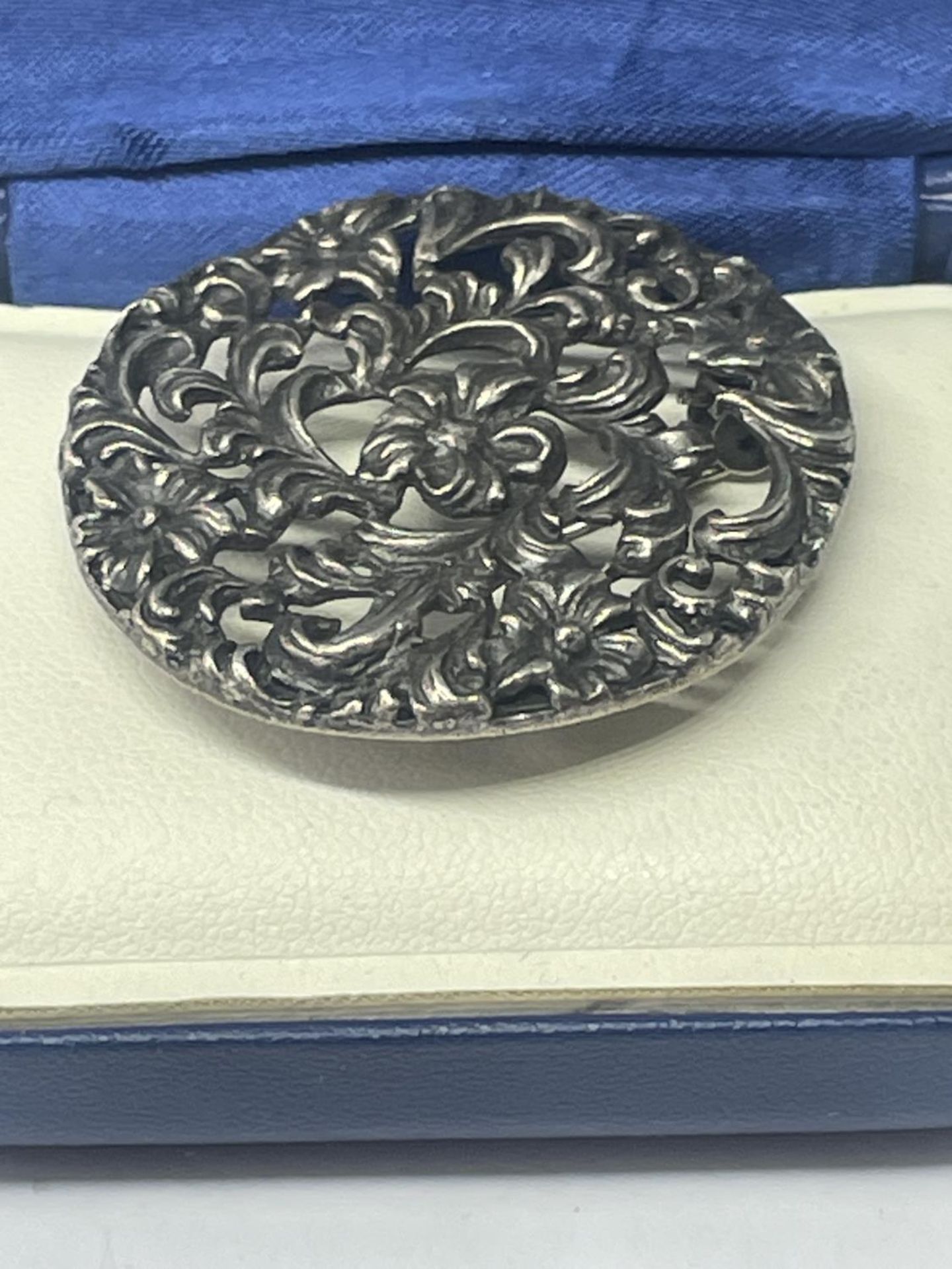 A SILVER BROOCH IN A PRESENTATION BOX