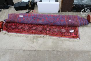 A VINTAGE RED PATTERNED FRINGED RUG