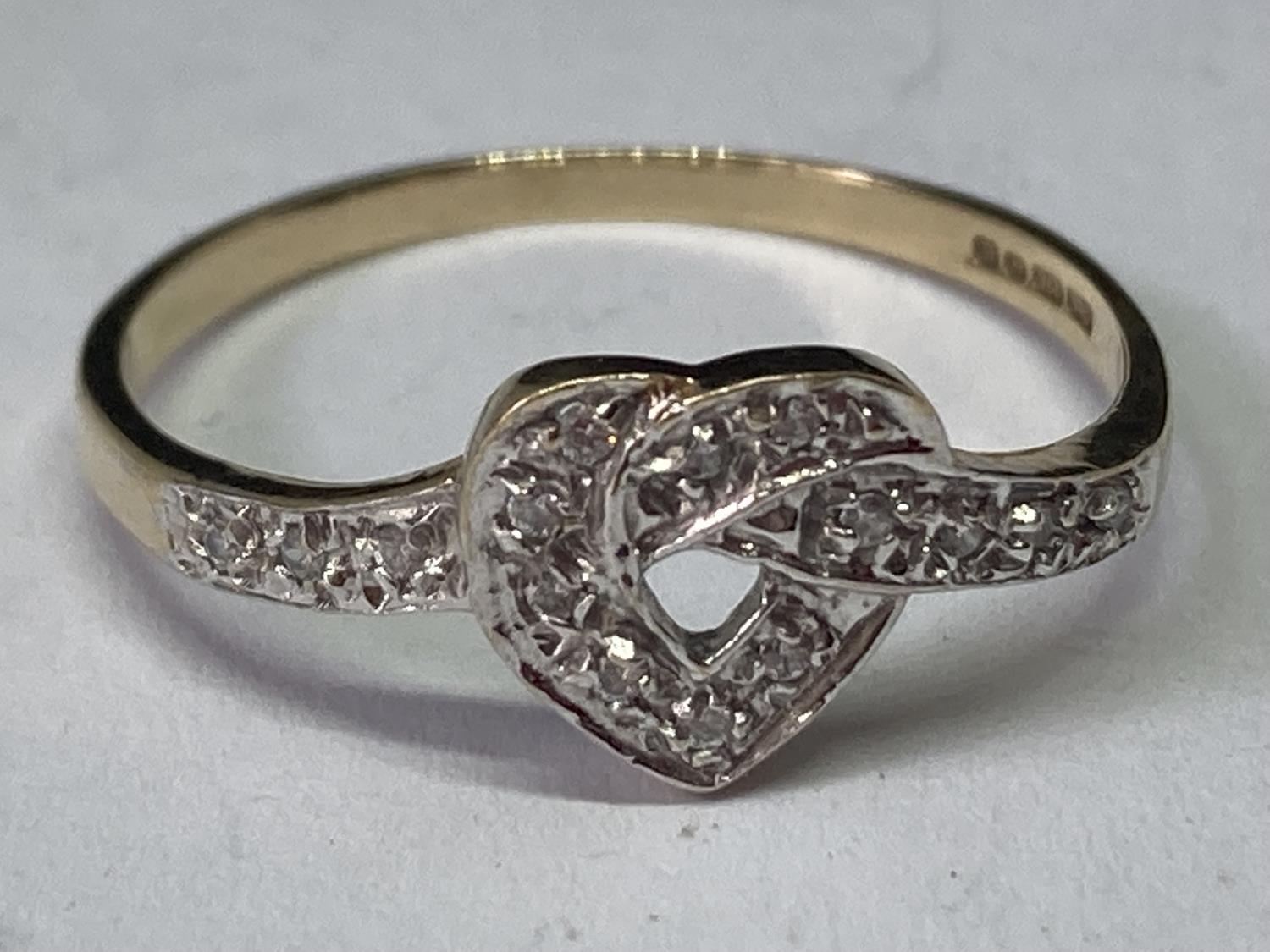 A 9 CARAT GOLD RING WITH DIAMONDS IN A HEART DESIGN SIZE R