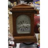 AN EDWARDIAN OAK CASED MANTLE CLOCK WITH PENDULUM, WORKING AT TIME OF CATALOGUING, NO WARRANTY