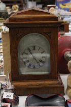 AN EDWARDIAN OAK CASED MANTLE CLOCK WITH PENDULUM, WORKING AT TIME OF CATALOGUING, NO WARRANTY