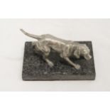 A WHITE METAL DOG ON A MARBLE STAND