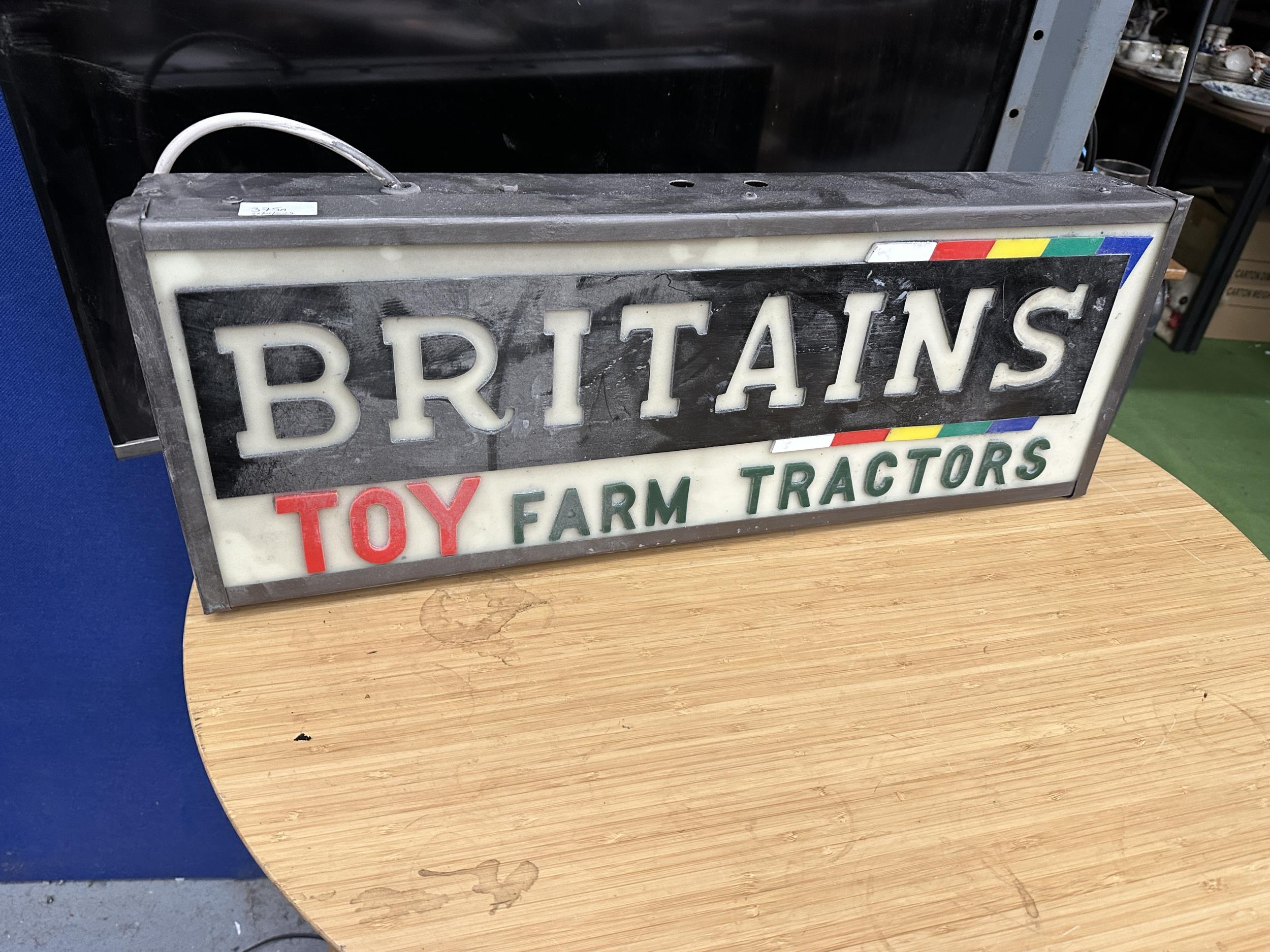 AN ILLUMINATED BRITAINS TOY FARM TRACTORS SIGN (L:68CM H:25CM)