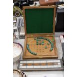 A BOXED WOODEN SOLITAIRE BOARD WITH MARBLES PLUS A VINTAGE CRIBBAGE BOARD