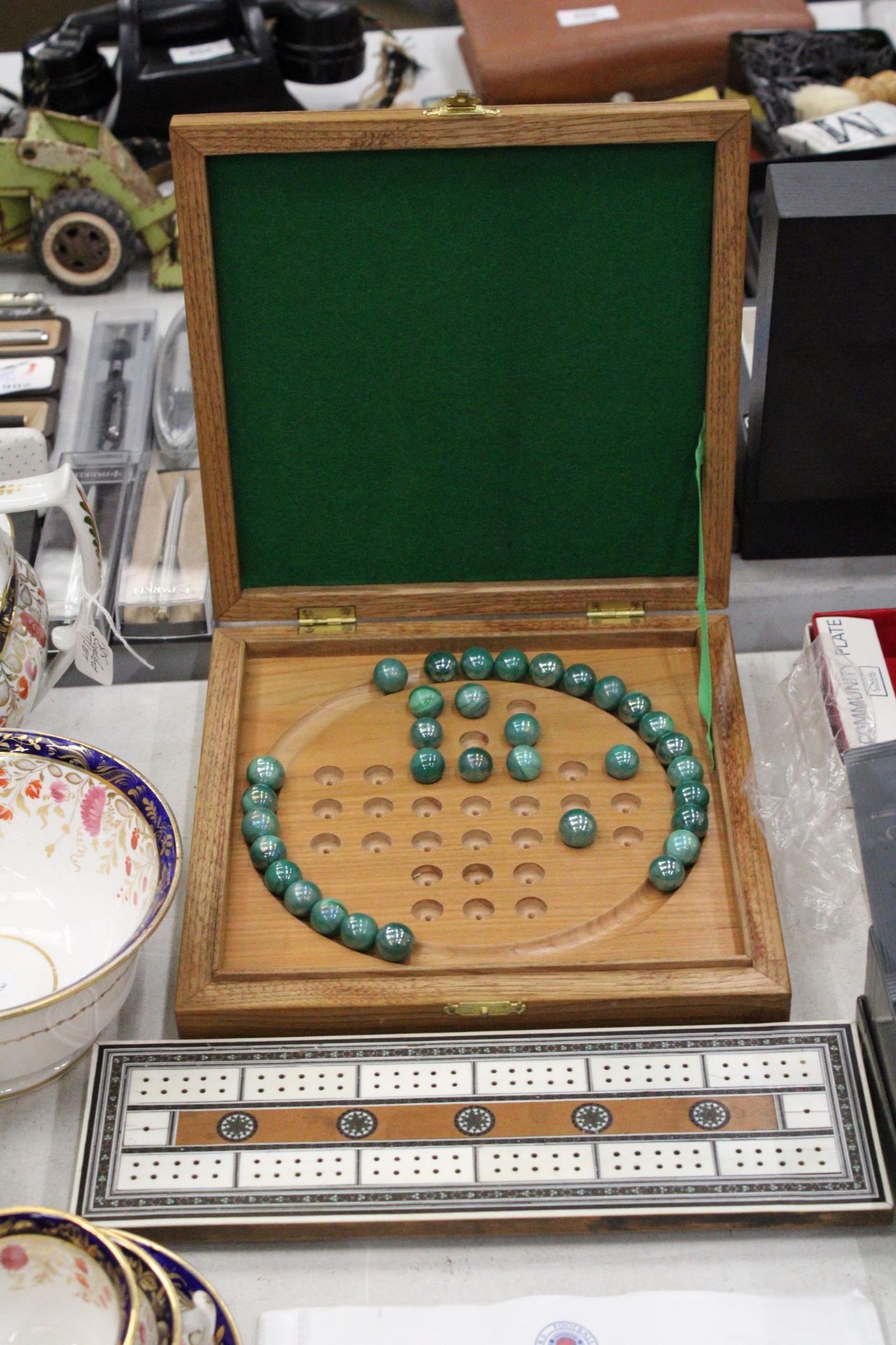 A BOXED WOODEN SOLITAIRE BOARD WITH MARBLES PLUS A VINTAGE CRIBBAGE BOARD