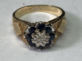 A 9 CARAT GOLD RING WITH A CENTRE DIAMOND SURROUNDED BY SAPPHIRES SIZE J