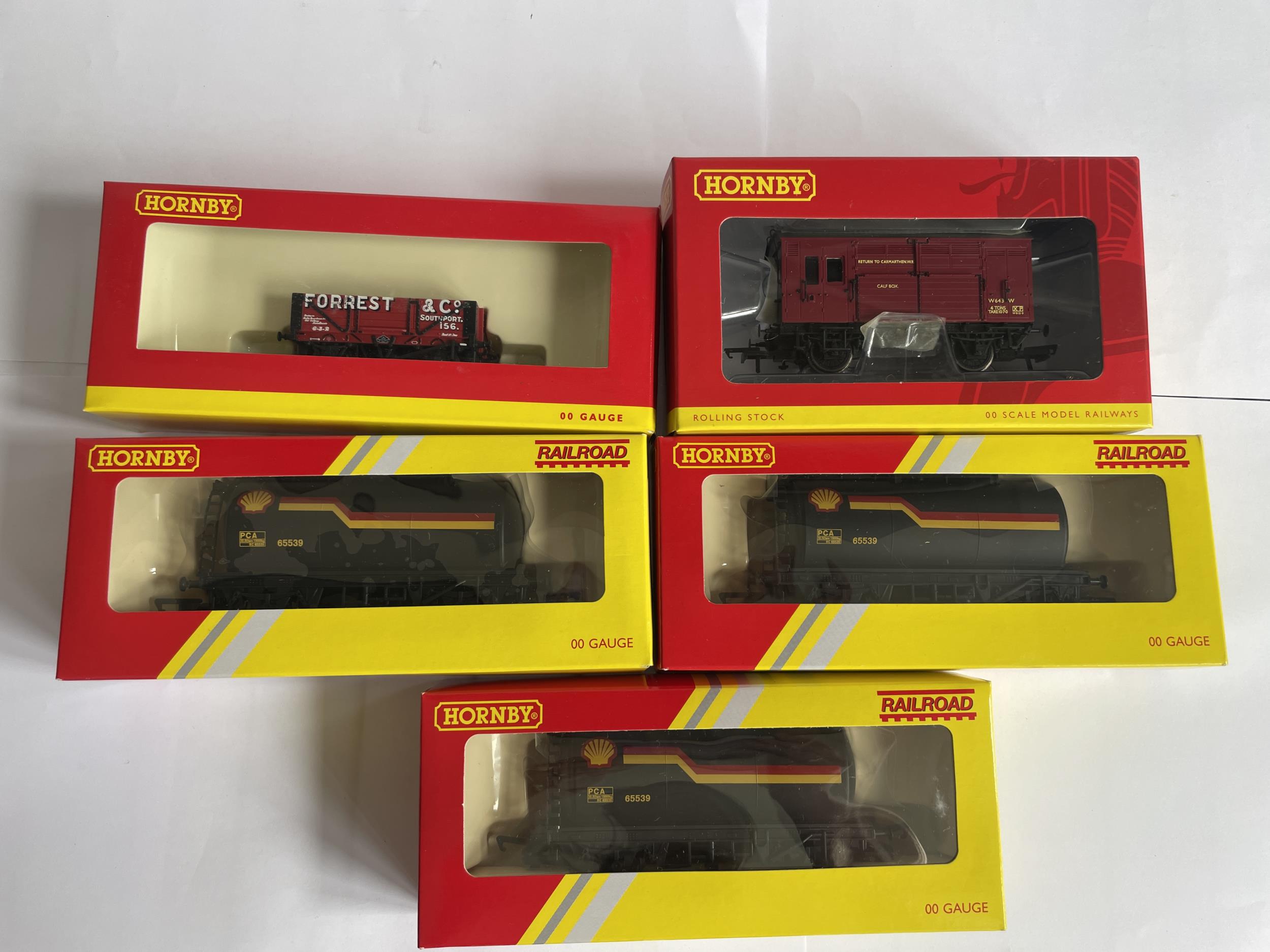 FIVE BOXED HORNBY 00 GAUGE FREIGHT CARRIAGES TO INCLUDE THREE SHELL TANKERS, A HORSE BOX AND A PLANK