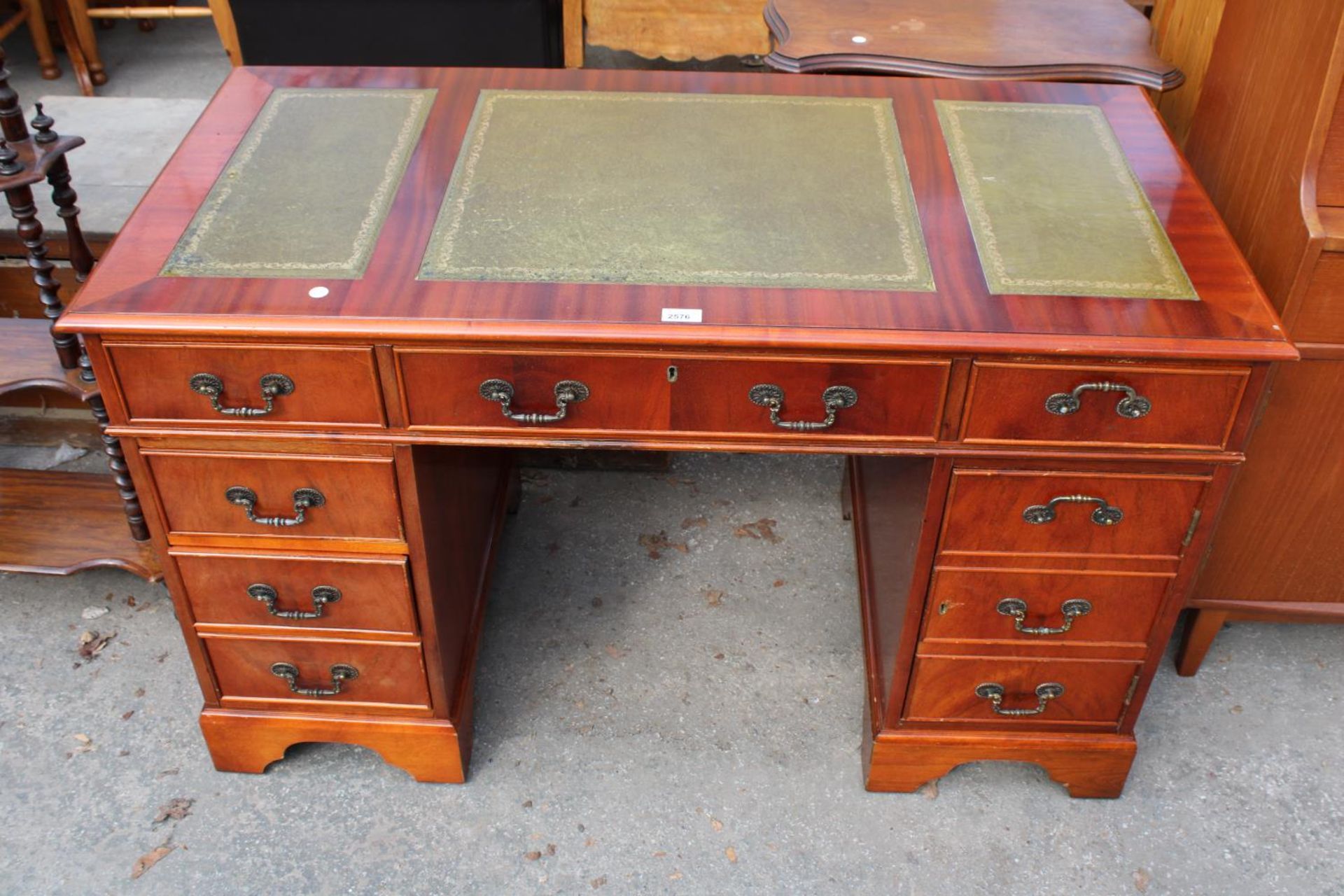 A MAHOGANY TWIN-PEDESTAL DESK ENCLOSING SIX DRAWERS AND ONE CUPBOARD WITH INSET LEATHER TOP, 48" X