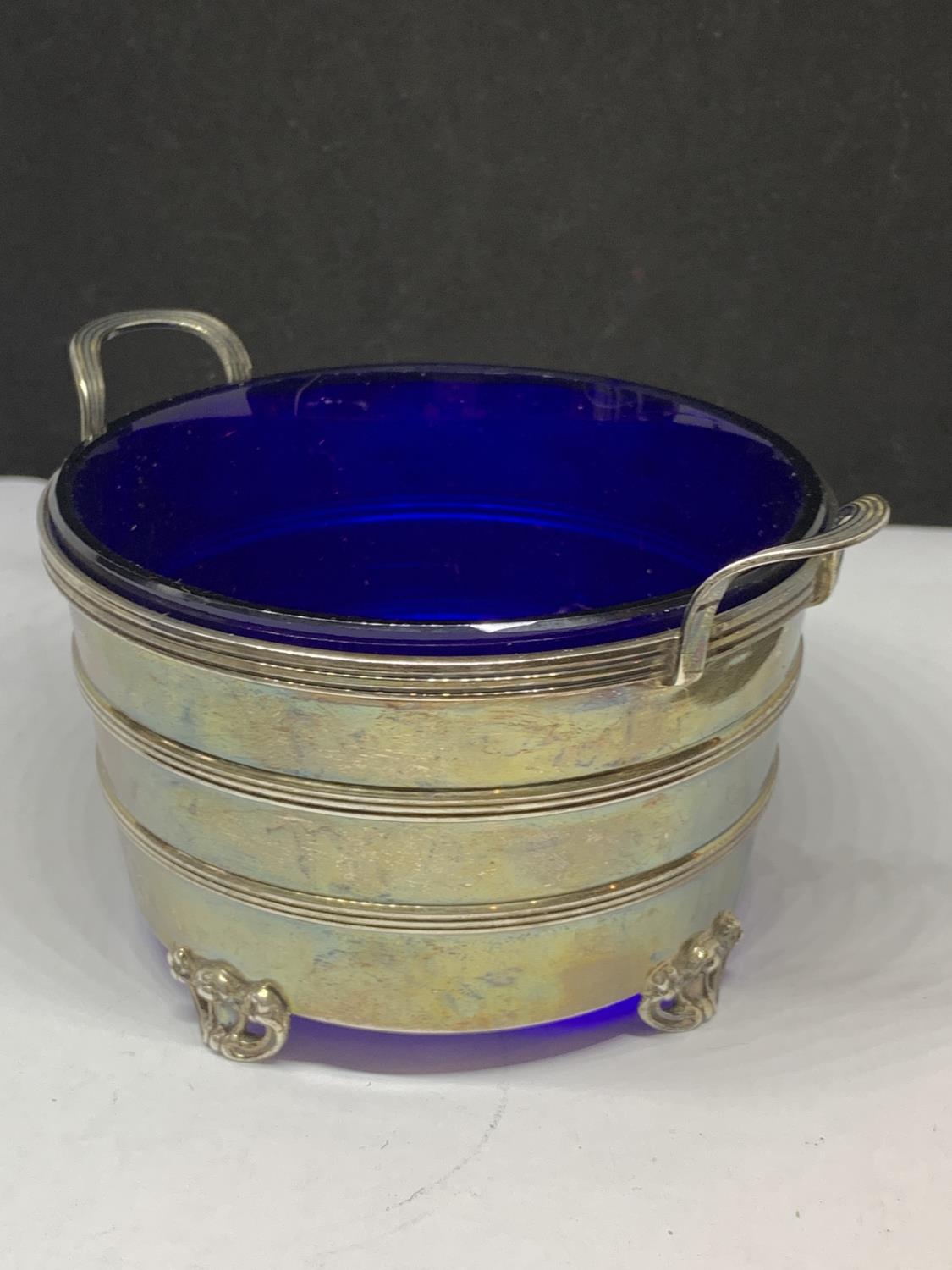 A HALLMARKED BIRMINGHAM SILVER TWIN HANDLED DEEP DISH ON FOUR DECORATIVE FEET WITH BLUE GLASS