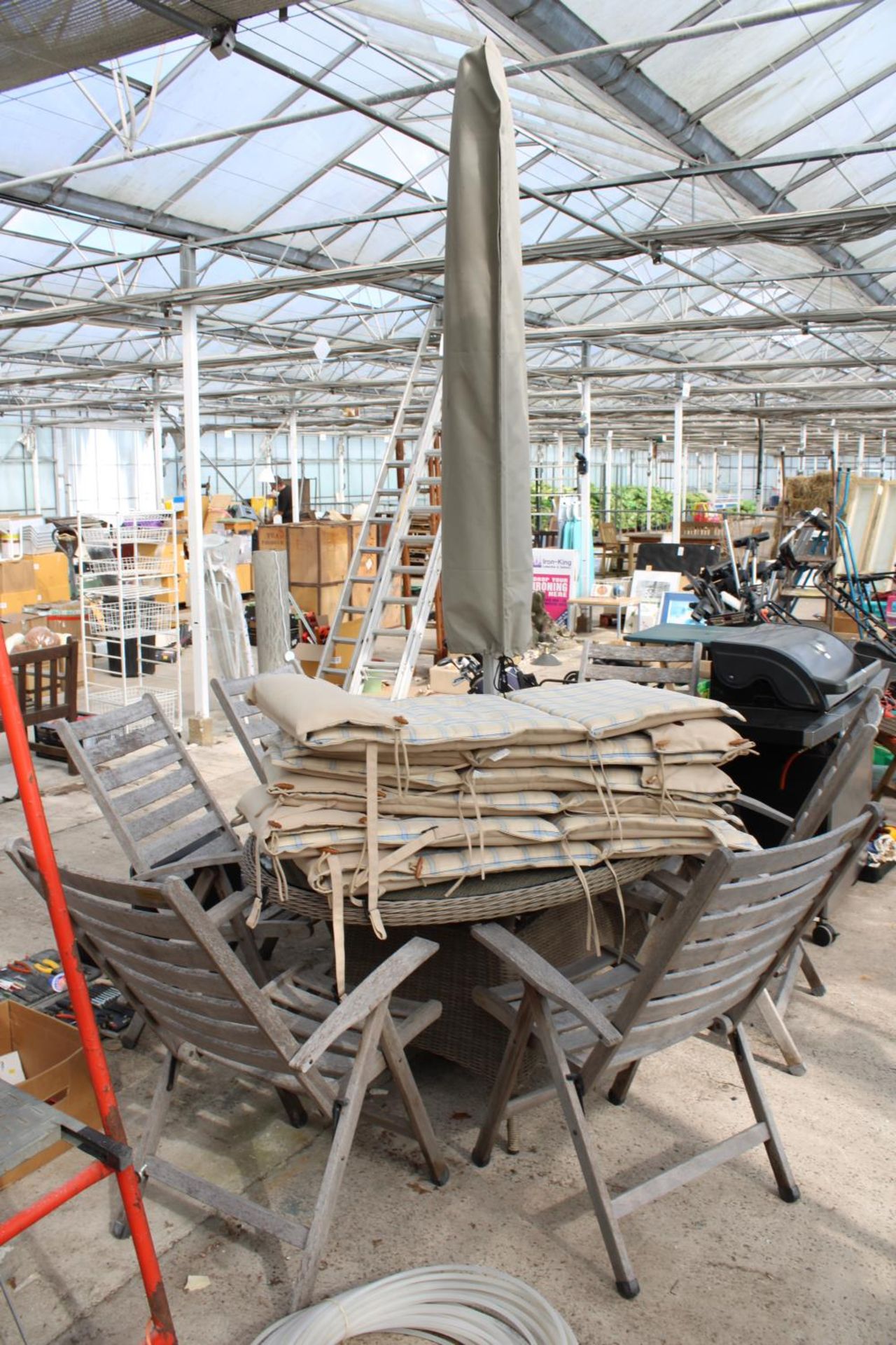 A RATTAN GARDEN TABLE WITH GLASS TOP, SIX FOLDING TEAK CHAIRS, CUSHIONS AND PARASOL WITH BASE - Image 2 of 4