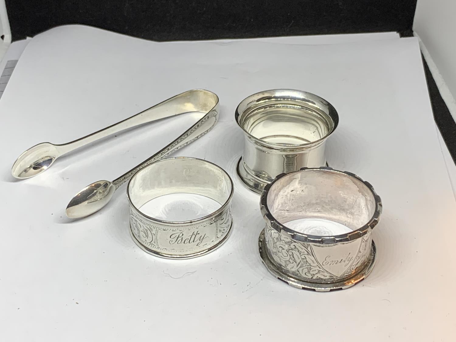 FOUR HALLMARKED SILVER ITEMS TO INCLUDE SHEFFIELD SUGAR NIPS AND THREE NAPKINS RINGS ONE BIRMINGHAM,
