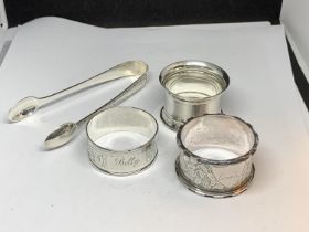 FOUR HALLMARKED SILVER ITEMS TO INCLUDE SHEFFIELD SUGAR NIPS AND THREE NAPKINS RINGS ONE BIRMINGHAM,