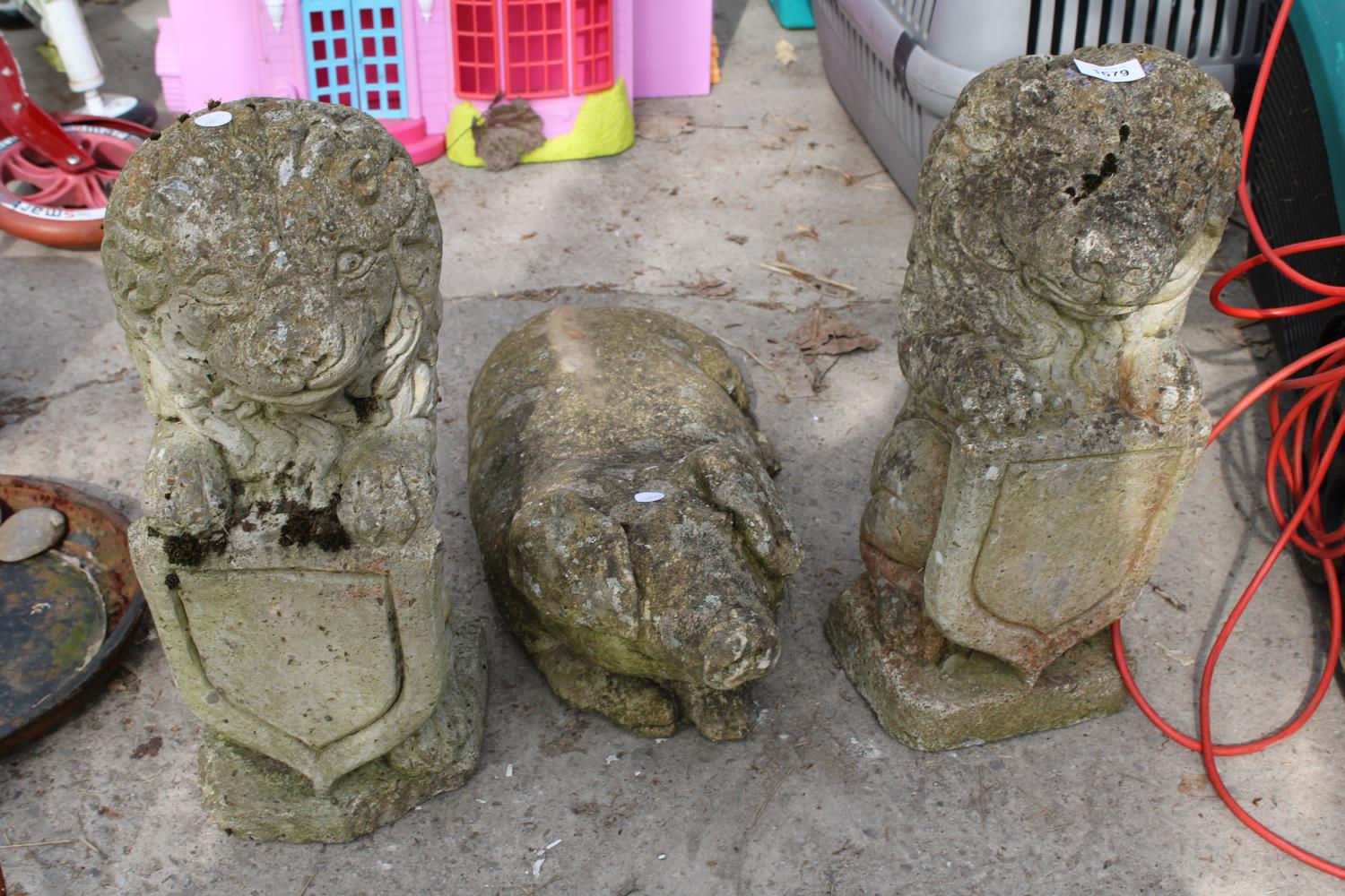 THREE RECONSTITUTED STONE GARDEN FIGURES TO INCLUDE A PAIR OF LIONS AND A PIG