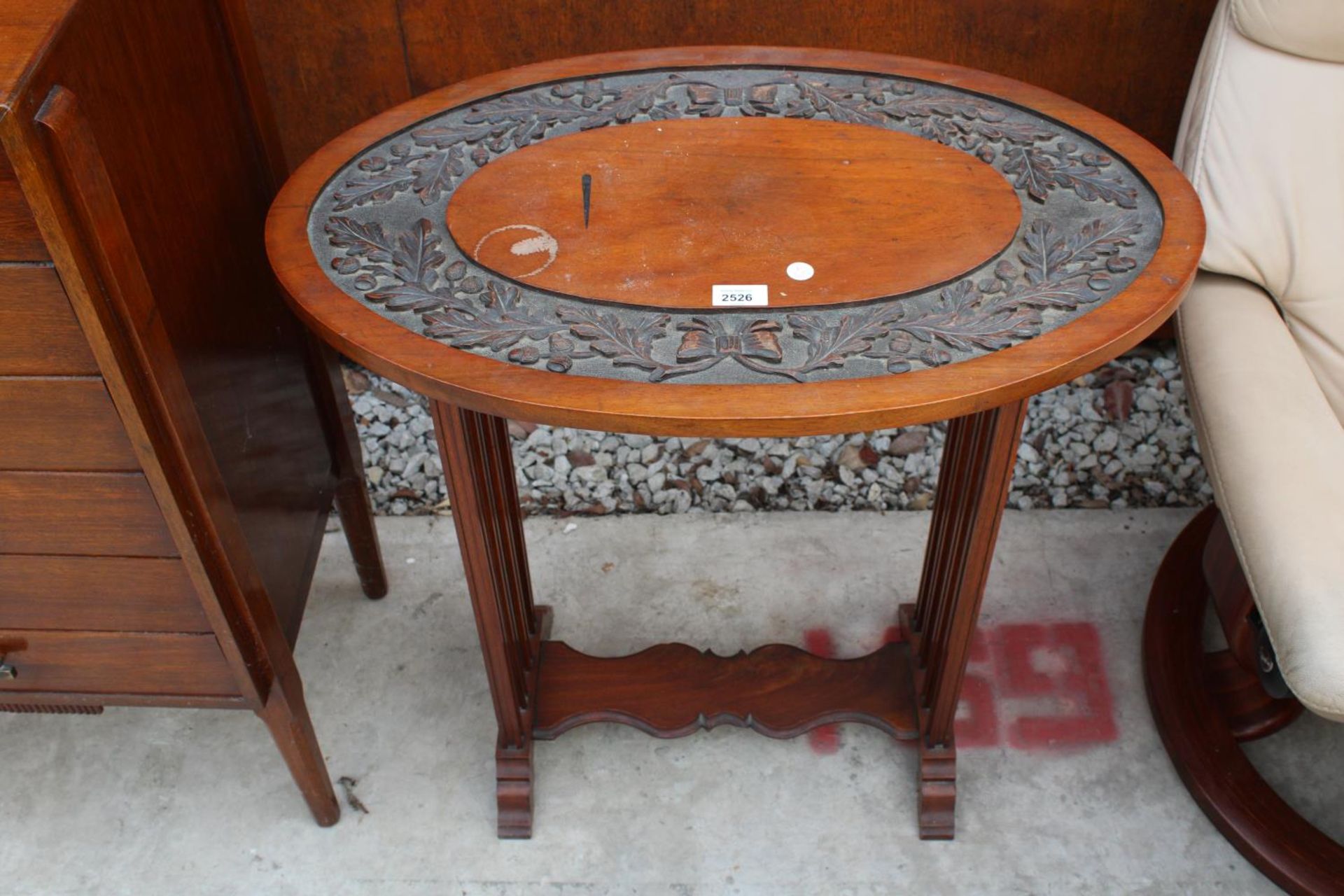 AN OVAL MAHOGANY CENTRE TABLE WITH CARVED ACORN AND LEAF DECORATION TO TOP 28" X 18"