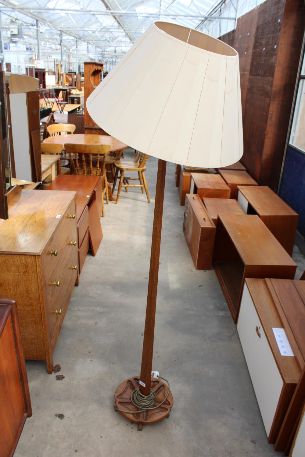 A 20TH CENTURY OAK STANDARD LAMP ON CLOVER LEAF SHAPED BASE WITH TAPERING COLUMN AND SHADE