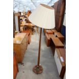 A 20TH CENTURY OAK STANDARD LAMP ON CLOVER LEAF SHAPED BASE WITH TAPERING COLUMN AND SHADE