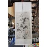 AN ORIENTAL SCROLL WITH BAMBOO DESIGN AND CHARACTER MARKS, ON PAPER BACKED MATERIAL, 60CM X 155CM