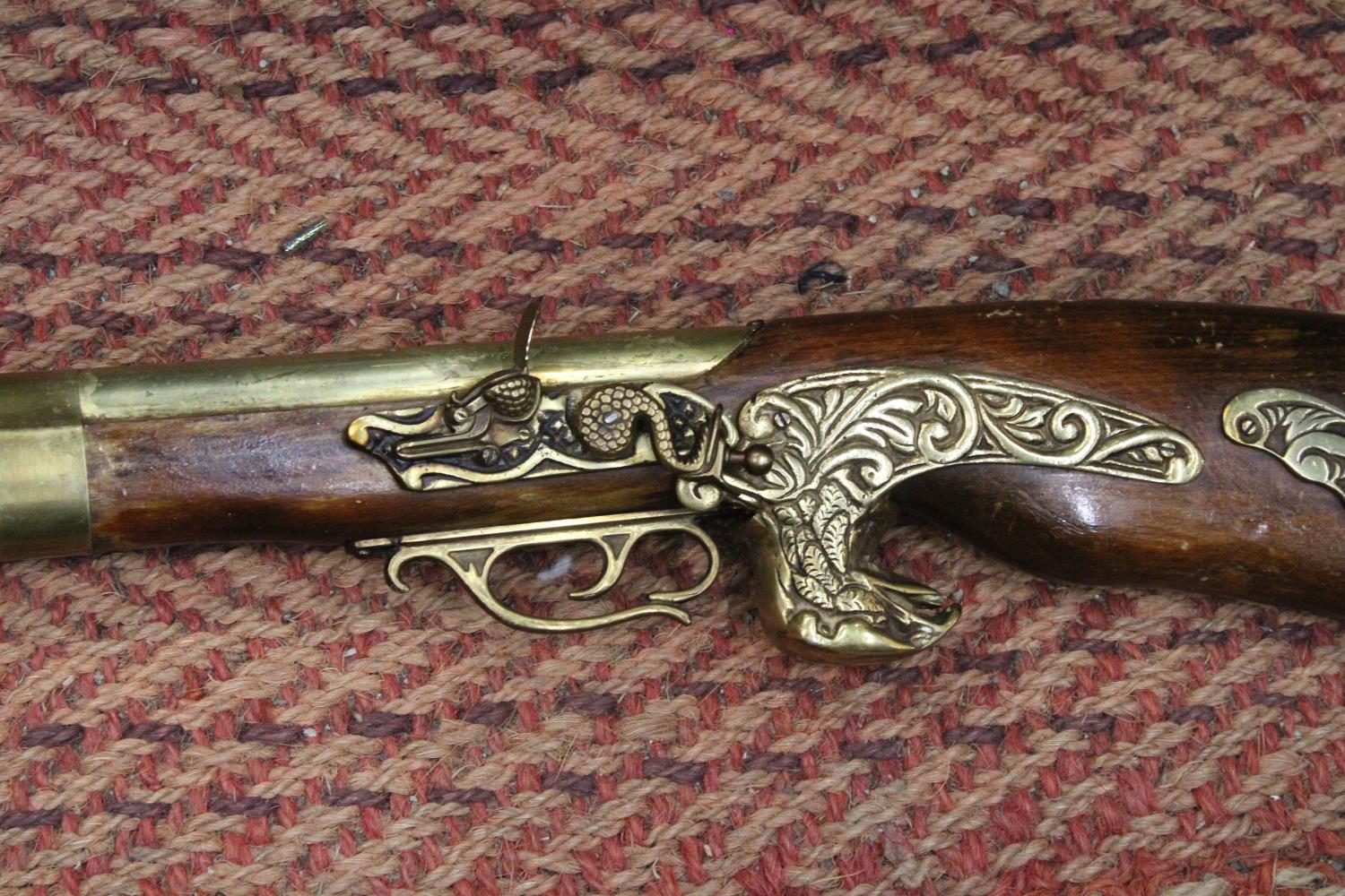 A HEAVY HARDWOOD AND BRASS WALL MOUNTED RIFLE -APPROXIMATELY 104CM - Image 2 of 3